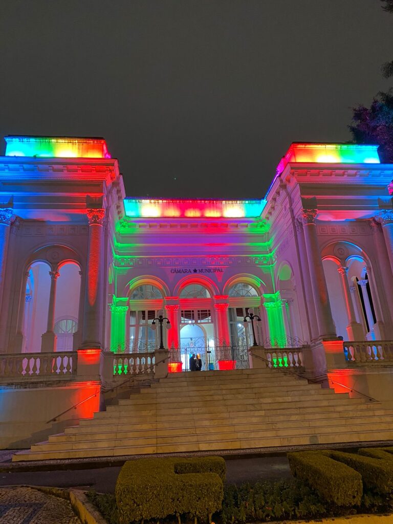 fachada iluminada com cores da bandeira gay